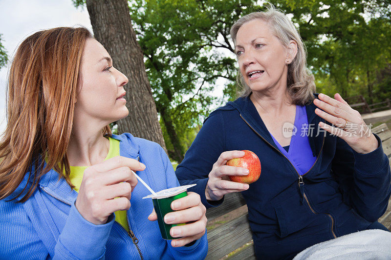 母亲和女儿在吃健康食品时进行严肃的谈话