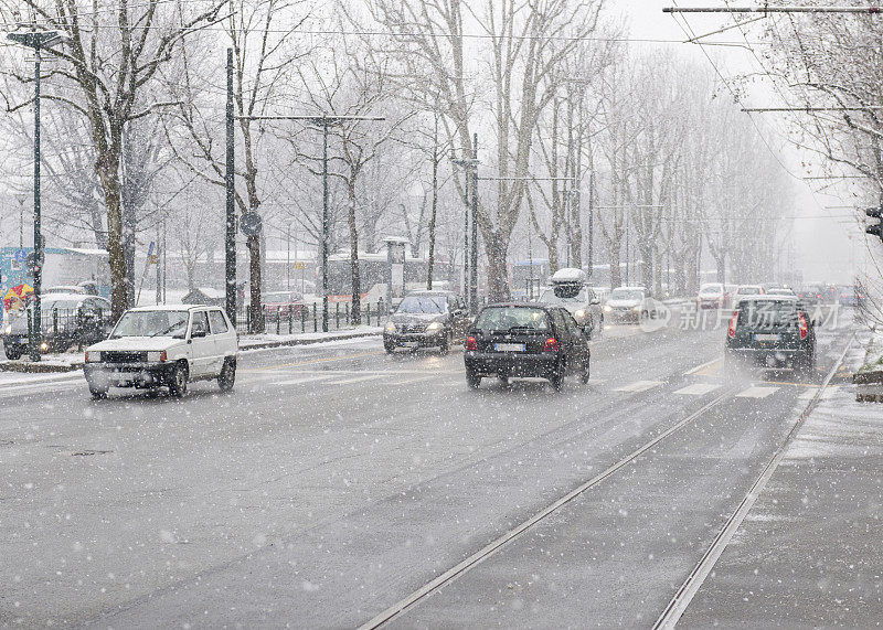 意大利下雪时城市街道上的汽车