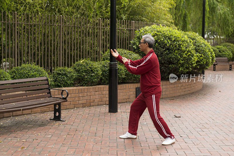 成熟的中国男子在公园里练习太极拳