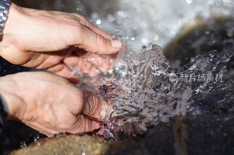 男子在清凉水中洗手(特写)