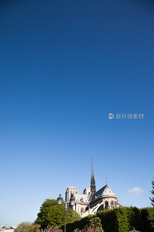 巴黎圣母院教堂和尖顶映衬着万里无云的蓝天