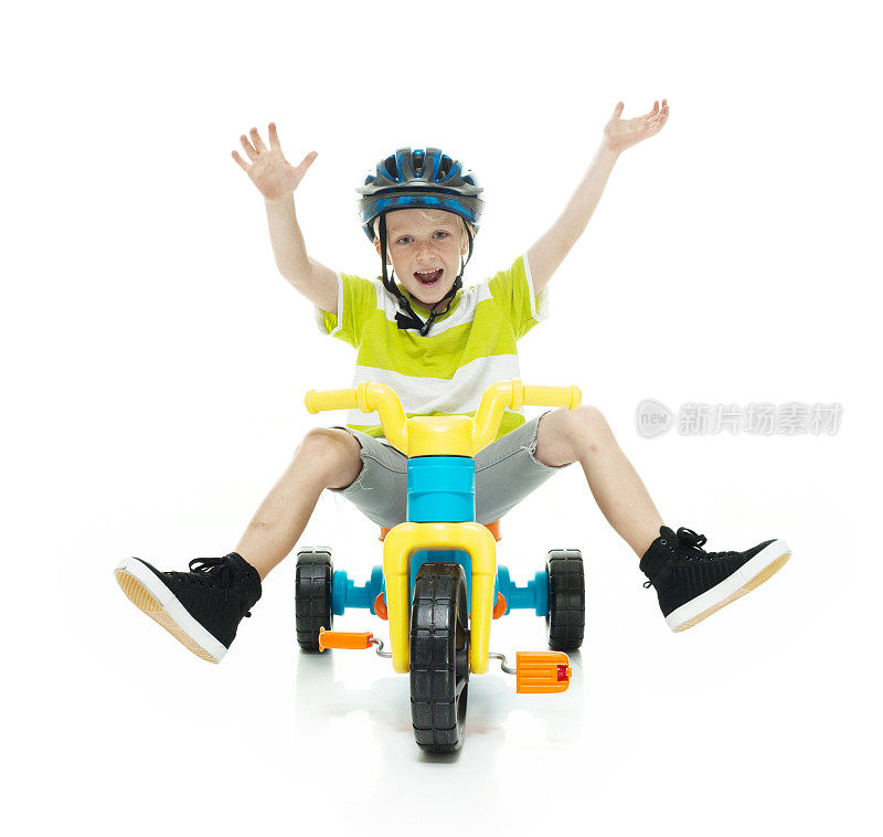 快乐的小男孩骑着三轮车