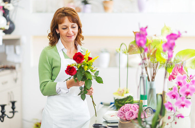 女花匠在花店制作玫瑰花束。