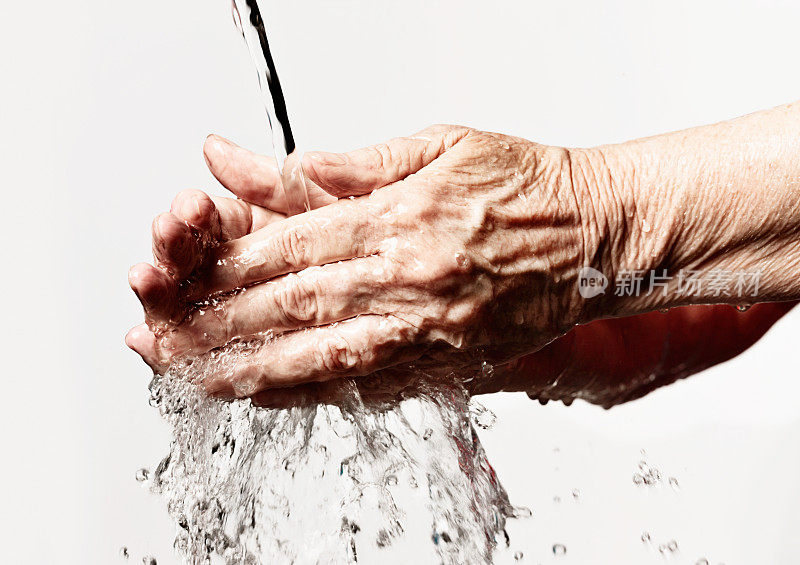 在自来水下洗起皱纹的手。良好的卫生实践。