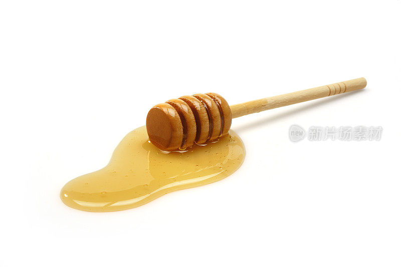 蜂蜜勺贴在白色背景的蜂蜜上