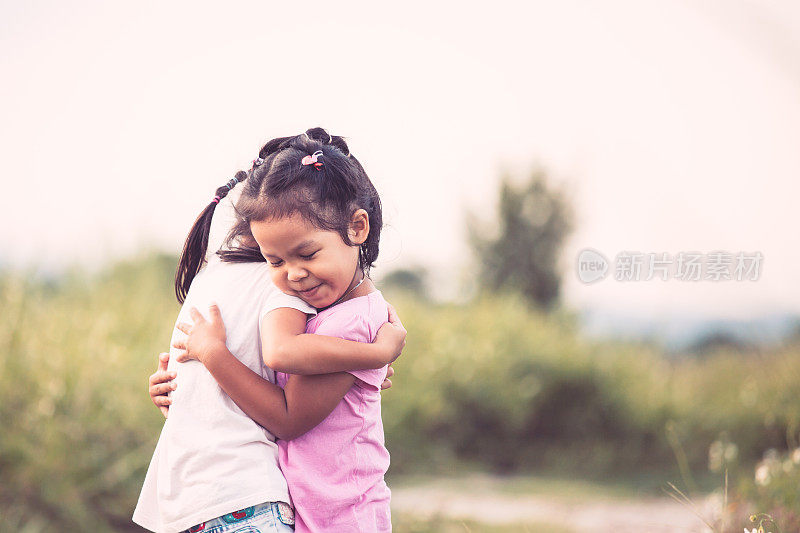 两个亚洲小女孩充满爱意地拥抱在一起