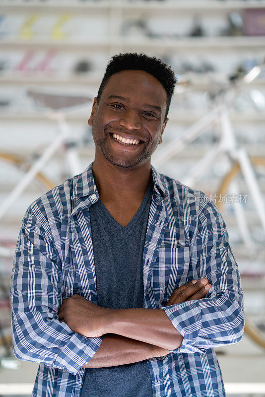 一个快乐的黑人企业主的自行车修理店微笑的肖像
