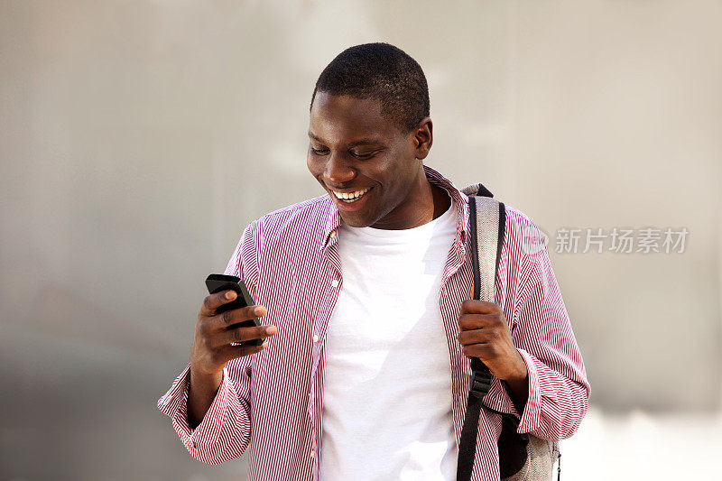 非洲大学生站在书包里看手机