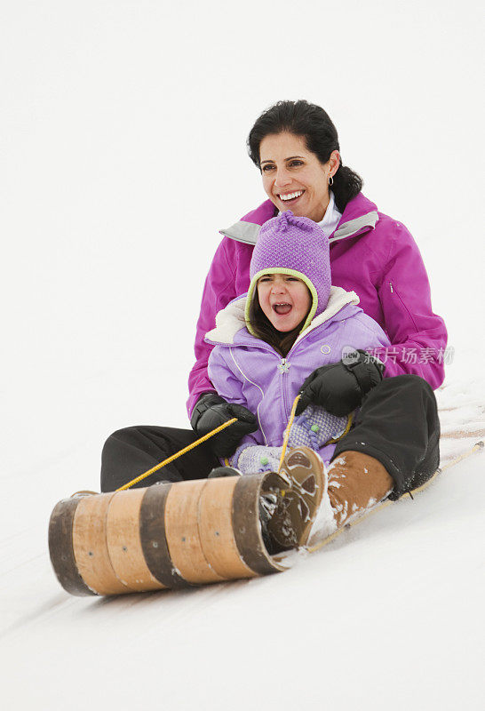 母亲和女儿一起坐雪橇