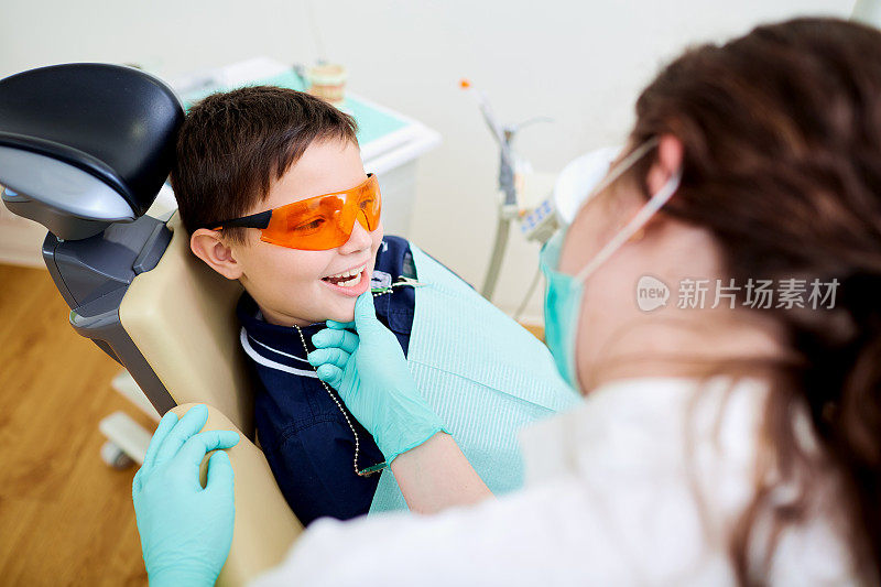 一个小孩在牙科诊所看牙医。牙科treatme