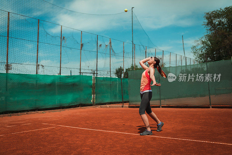 在红土场上进行比赛的年轻网球运动员