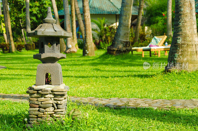 巴厘岛-小宝塔和棕榈树与绿色草地在日出放松