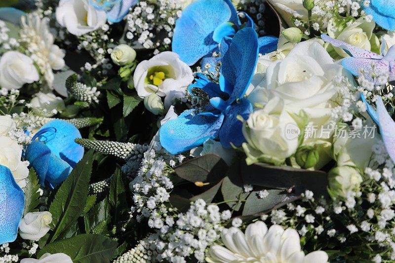 由白玫瑰和蓝色兰花组成的伴娘花束