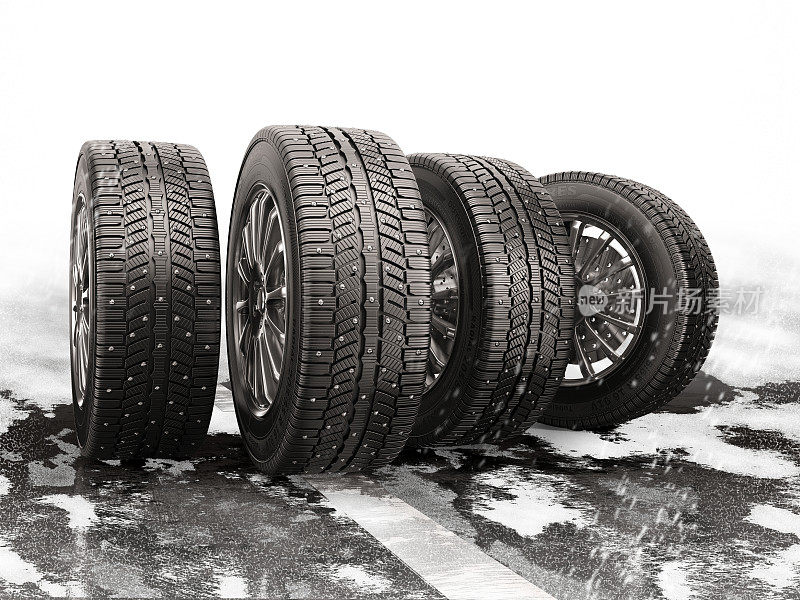 四个汽车轮胎在积雪覆盖的道路上滚动。