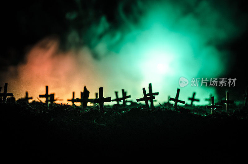 僵尸的剪影在夜里走过墓地。恐怖万圣节的概念，一群僵尸在晚上