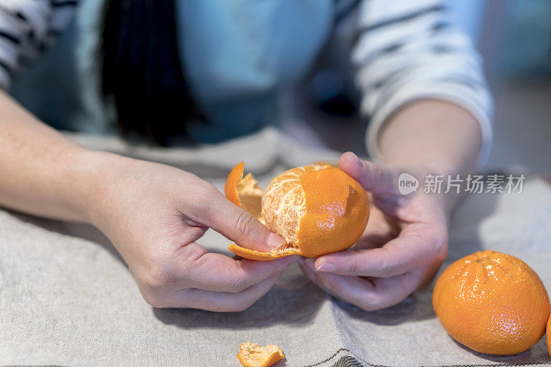 女孩正在剥新鲜的橘子