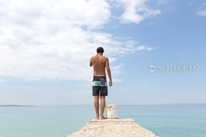 夏天，穿着短裤的人站在码头的尽头