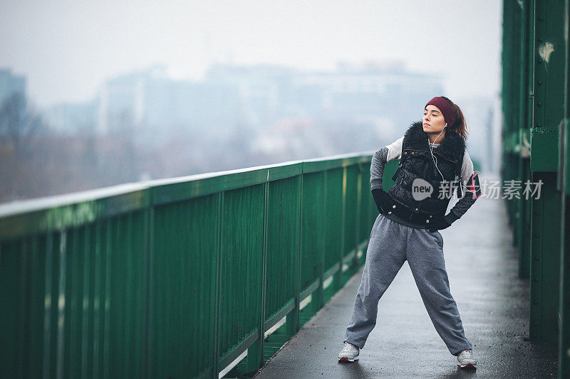 年轻女子在恶劣的天气条件下跑步和锻炼