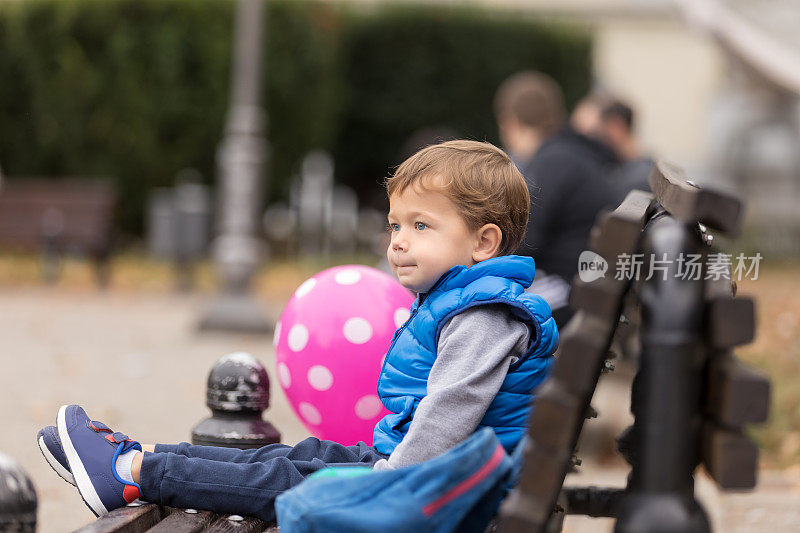 坐在长凳上的小男孩