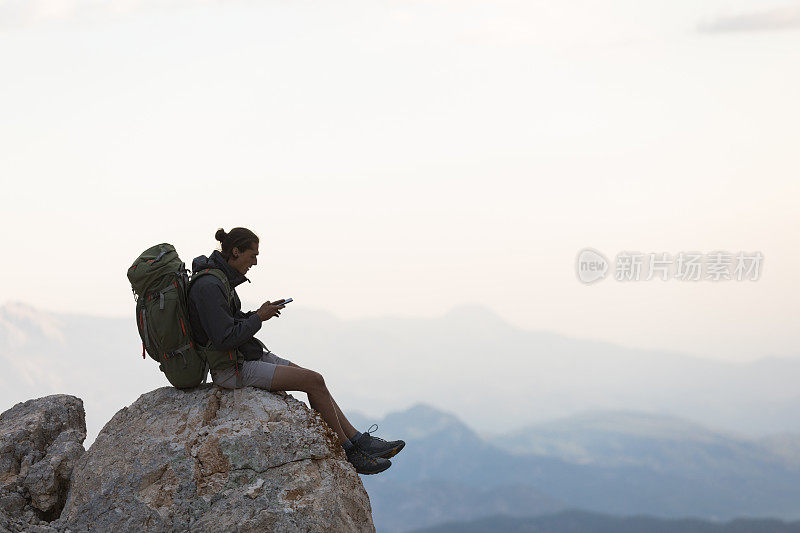 登山者在山顶使用智能手机