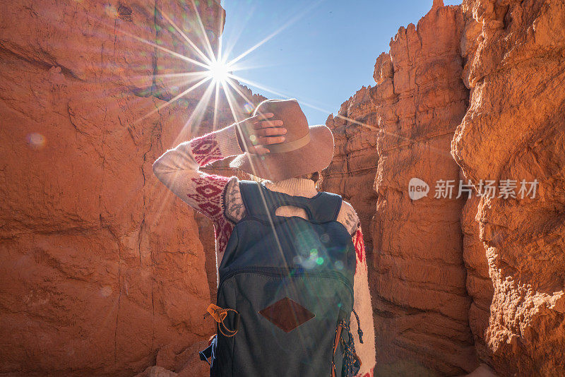 年轻女子在美国犹他州的布莱斯峡谷国家公园旅行，人们在旅行中探索自然。女孩在红色岩层中徒步旅行