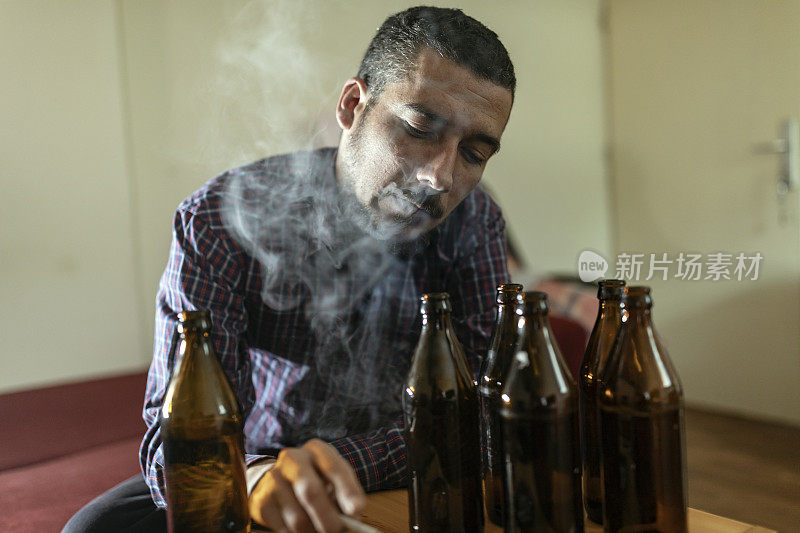 年轻悲伤的醉酒男子喝啤酒和酒精感到浪费，孤独和绝望的痛苦和情绪压力。人与酗酒、上瘾和男人抑郁的概念。