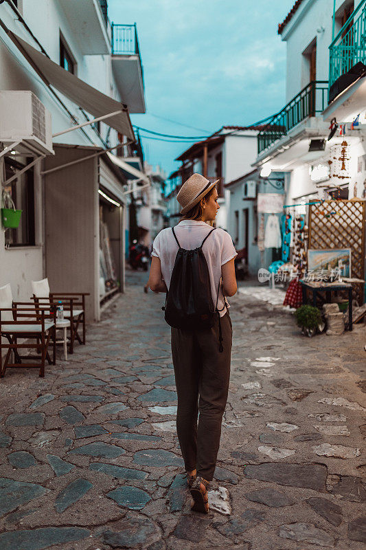 在希腊岛上度假期间，女人在城市街道上