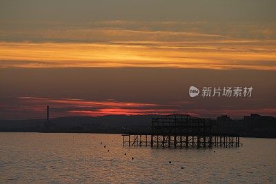 布赖顿西码头与戏剧性的日落天空在海上和城市沿海天际线布赖顿，东苏塞克斯，英国，从布赖顿码头，布赖顿海滩的黄昏照片