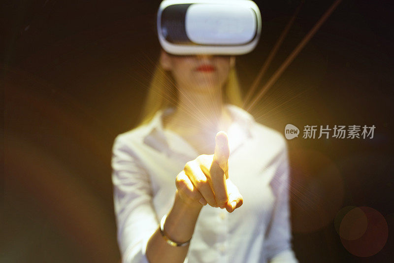 年轻女性佩戴VR眼镜，与虚拟现实互动，娱乐和创新的技术理念