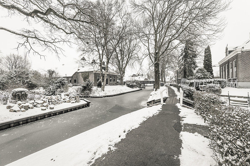 在一个寒冷但美丽而平静的冬天，Giethoorn村的运河和积雪