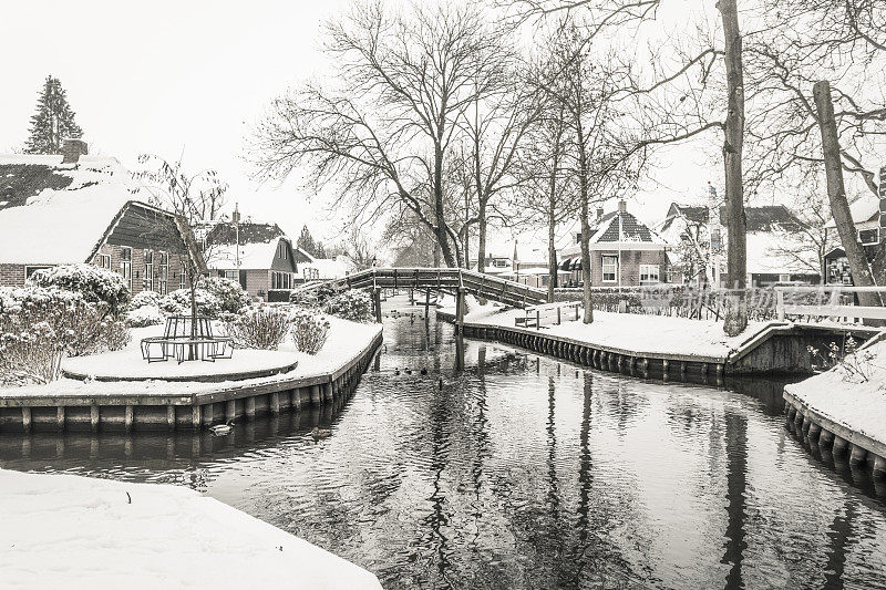 在一个寒冷但美丽而平静的冬天，Giethoorn村的运河和积雪