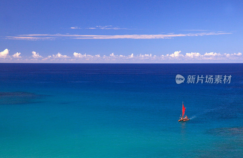 在绿松石热带海上的红色帆船