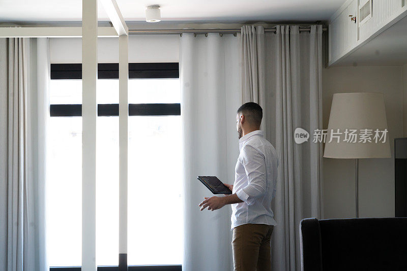 一个商人在他的酒店房间里用他的数字平板电脑排练演示