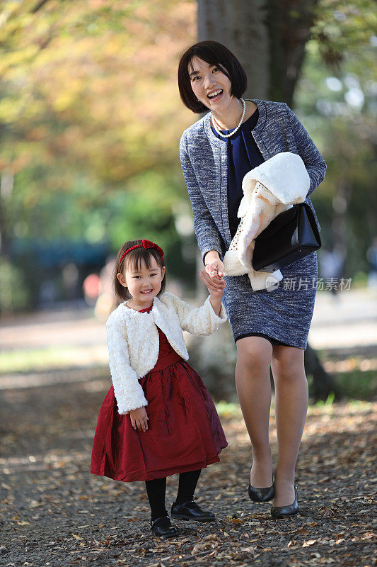 日本母亲与她的女儿走在志一去桑庆祝