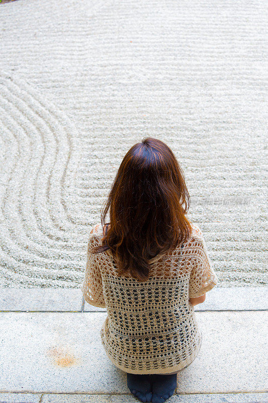 年轻女子在寺庙前祈祷