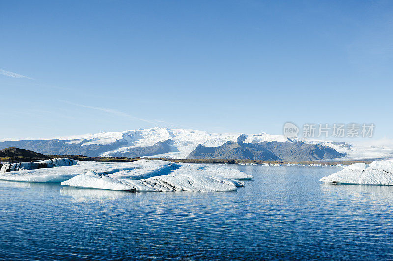 Jokulsarlon泻湖,冰岛。冰川湖的风景与大冰块的背景山，清澈的蓝天和清澈的水