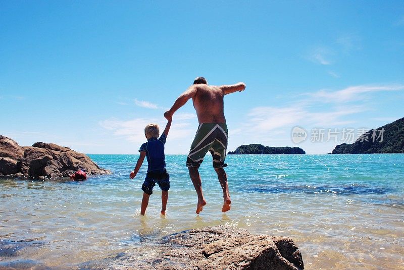 男人和男孩在夏天跳进海里