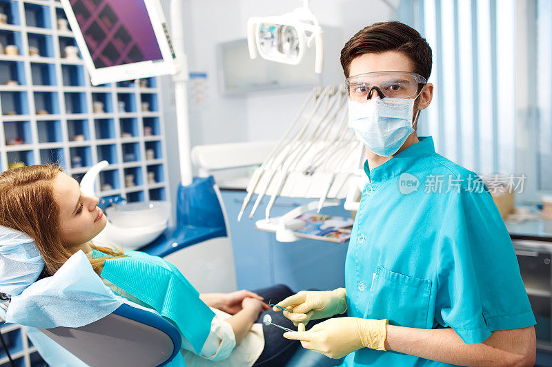 牙医检查年轻女子的牙齿。