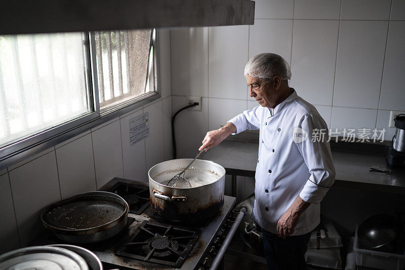 高级厨师在一个工业厨房里准备油炸食品