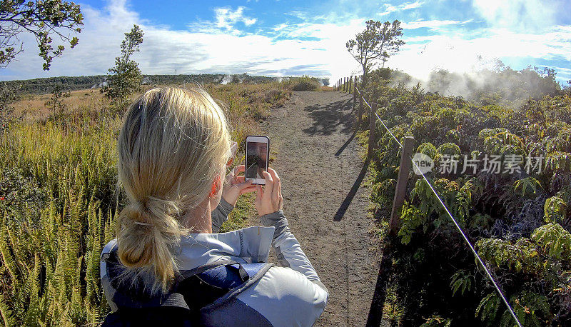 一名女子探索了环形山边缘小道，Kīlauea的火山口