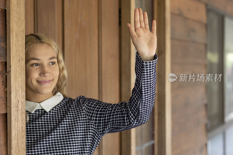 一个年轻女人站在房子的前门