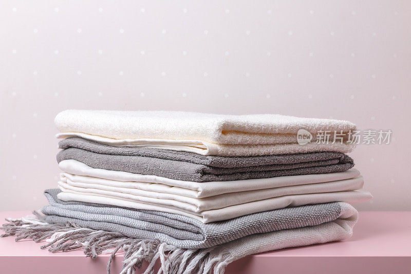 桌子上一叠卷好的毯子、床单和毛巾