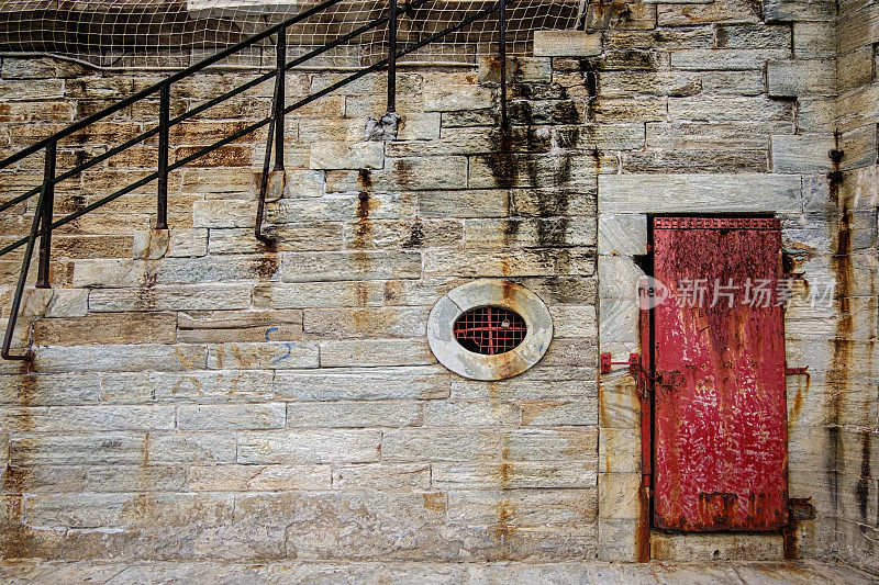 法国科西嘉巴斯蒂亚的老港口(维厄港)墙上生锈的红色门。