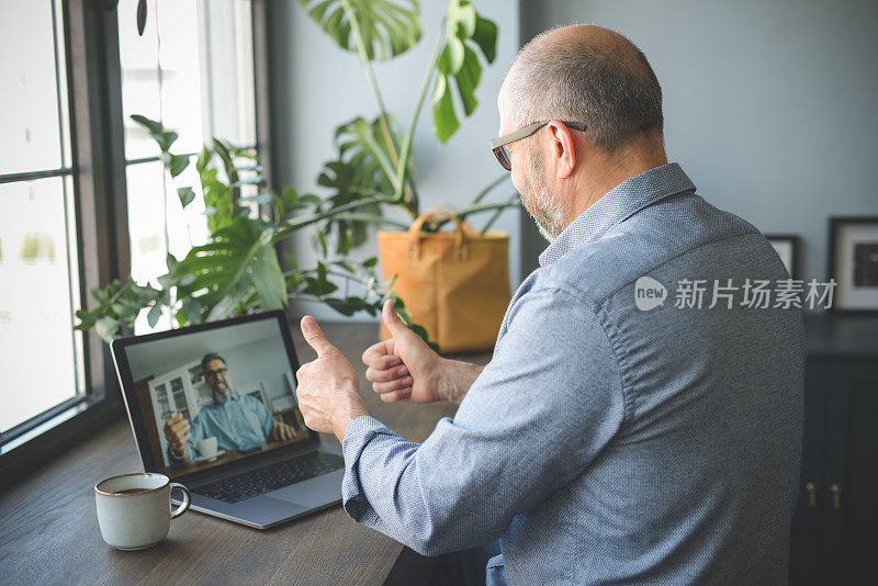 成年男性在家办公(使用笔记本电脑，视频会议)