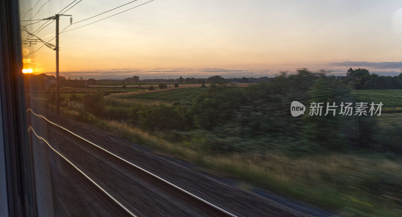 从高速行驶的火车上看日落，模糊的运动，交通和旅行，假期