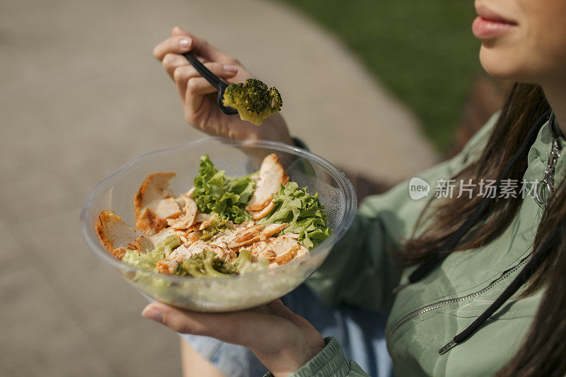 一个白人妇女在公园吃她的午餐的特写