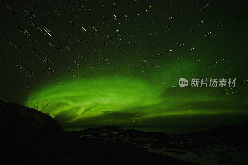 绿色的北极光在夜空和星星的轨迹