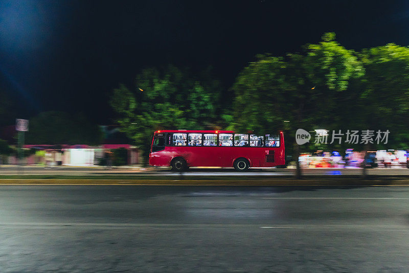 墨西哥坎昆-城市巴士在夜间通过街道的运动
