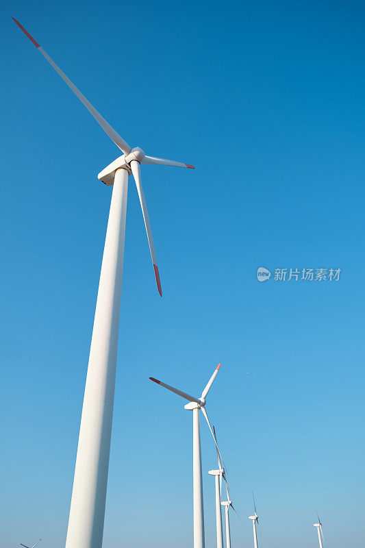 风力涡轮机在蓝天上生产绿色可再生能源