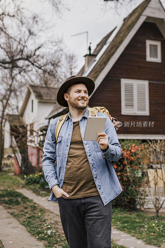 年轻的男性游客在用他的数码平板电脑